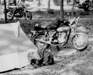 Joe sleeping on his Commando at a campsite.